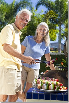 Happy Senior Couple Outside Cooking on A Summer Barbecue